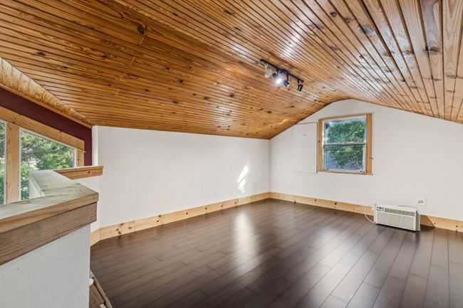 Bonus room featuring wooden ceiling, a wall mounted air conditioner, plenty of natural light, vaulted ceiling, and baseboards | Image 24