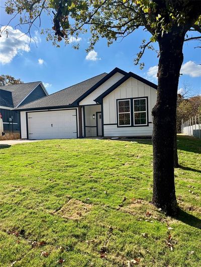 Ranch-style house featuring a front lawn and a garage | Image 1