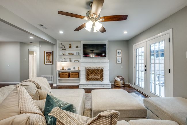 Living area featuring ceiling fan, recessed lighting, wood finished floors, and a brick fireplace | Image 15