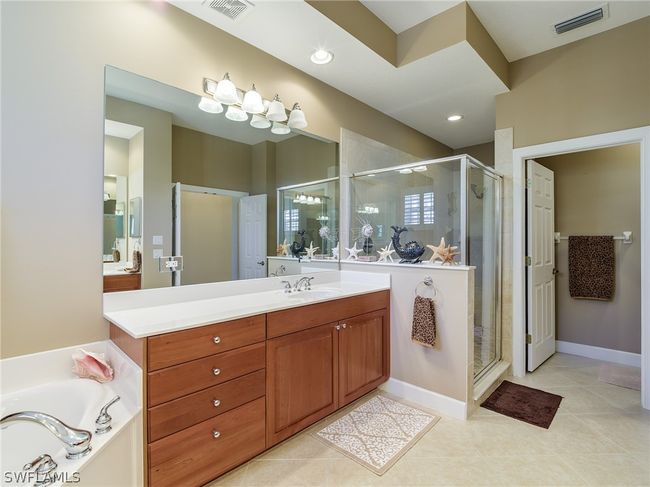 Bathroom featuring shower with separate bathtub, vanity, and tile floors | Image 18