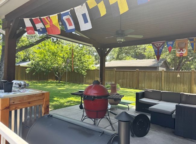 Airy, covered back porch is perfect for lounging with a book or entertaining. | Image 17