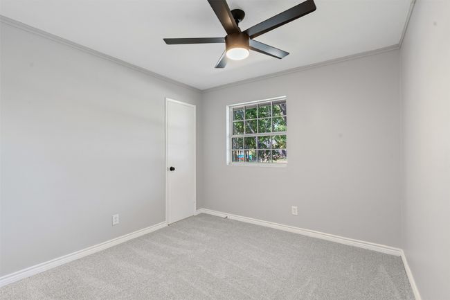 Carpeted empty room with ceiling fan and crown molding | Image 15