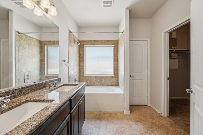 Full bathroom featuring double vanity, a closet, and shower combination | Image 22