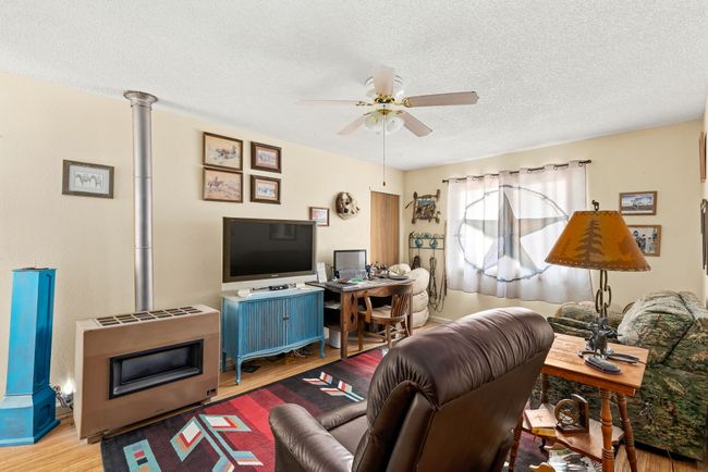 Additional apartment Living area featuring a textured ceiling, wood finished floors, and a ceiling fan | Image 67