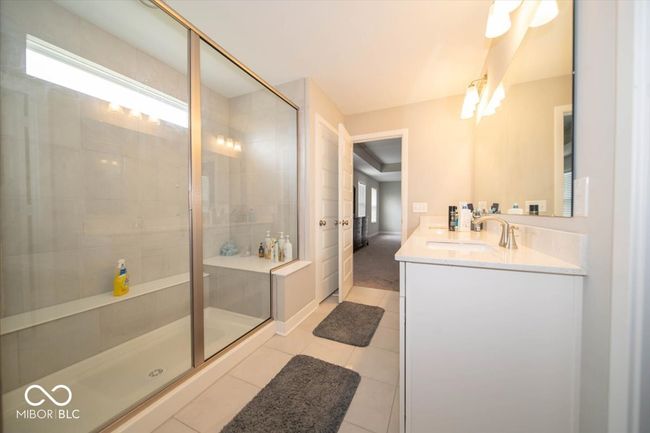 full bathroom featuring double vanity, a stall shower, and tile patterned flooring | Image 19