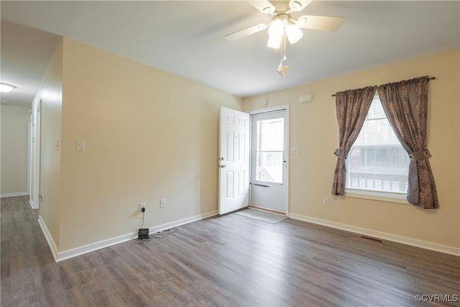 Unfurnished room featuring a wealth of natural light, visible vents, wood finished floors, and baseboards | Image 5