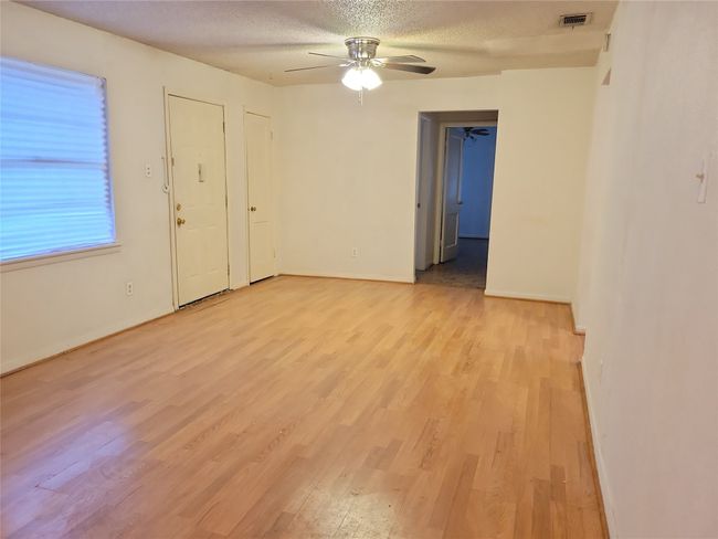 Unfurnished room with light wood finished floors, ceiling fan, a textured ceiling, and baseboards | Image 7