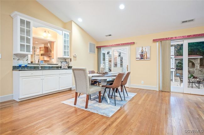 This 29' x 23' Florida room open space with vaulted ceilings, a built-in wet bar, three French doors, and warm hardwoods | Image 23