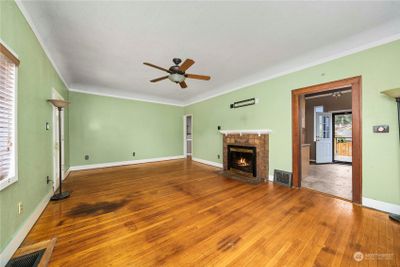 Cozy fireplace in living room with high ceilings and crown moulding. | Image 2