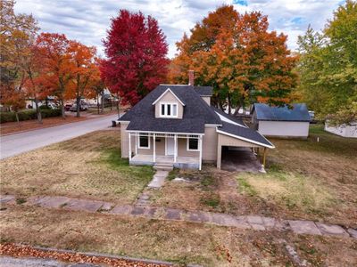 New england style home featuring a porch and a front lawn | Image 2