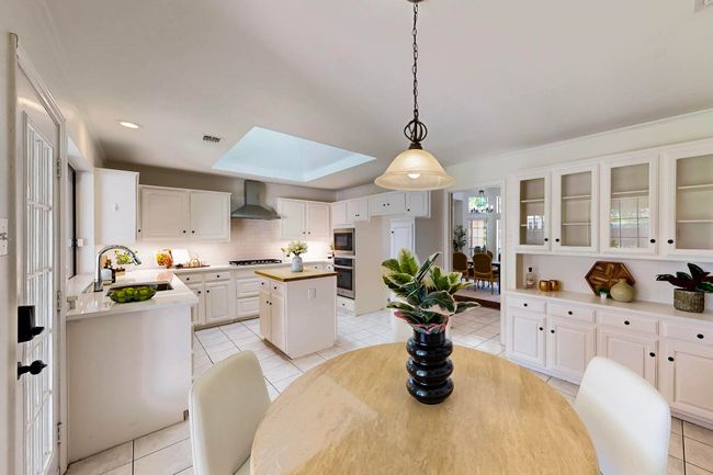 Dining area with a skylight, light tile patterned floors, and recessed lighting | Image 12