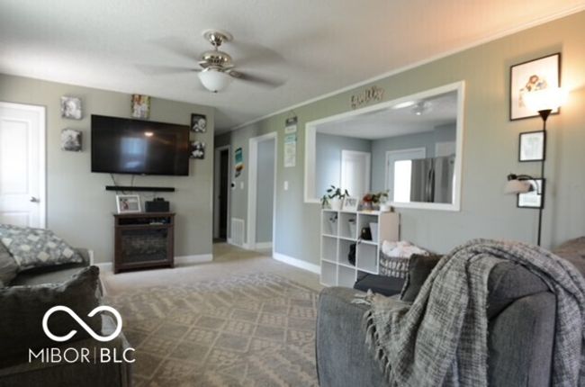 carpeted living area featuring visible vents, baseboards, and ceiling fan | Image 31