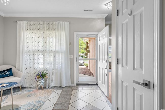 Entryway featuring light tile patterned flooring, crown molding, inlaid floor details, and baseboards | Image 4