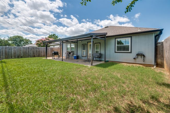 Rear view of house featuring a fenced backyard, a patio area, and a shingled roof | Image 23