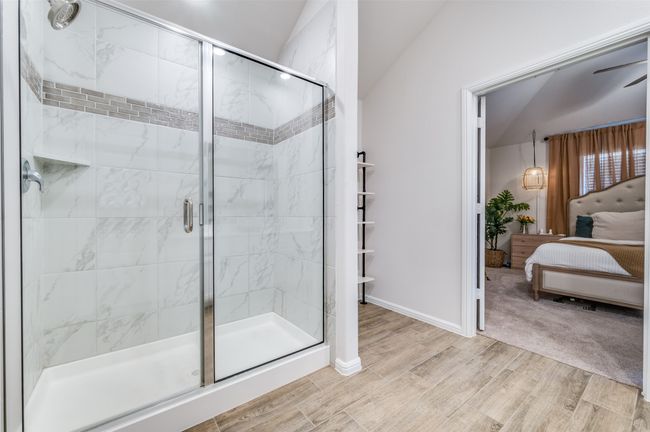 Ensuite bathroom featuring ensuite bathroom, baseboards, a stall shower, and wood finished floors | Image 16