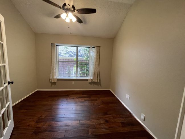 Spare room with a ceiling fan, dark wood-type flooring, a textured ceiling, and lofted ceiling | Image 12