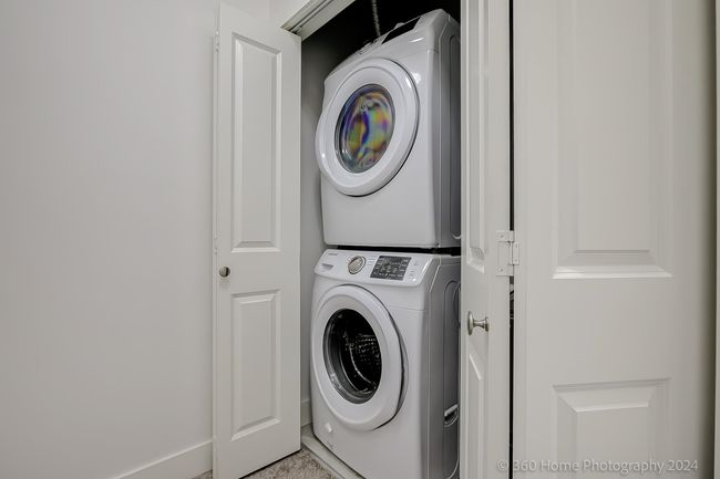 Laundry room featuring stacked washing machine and dryer | Image 16