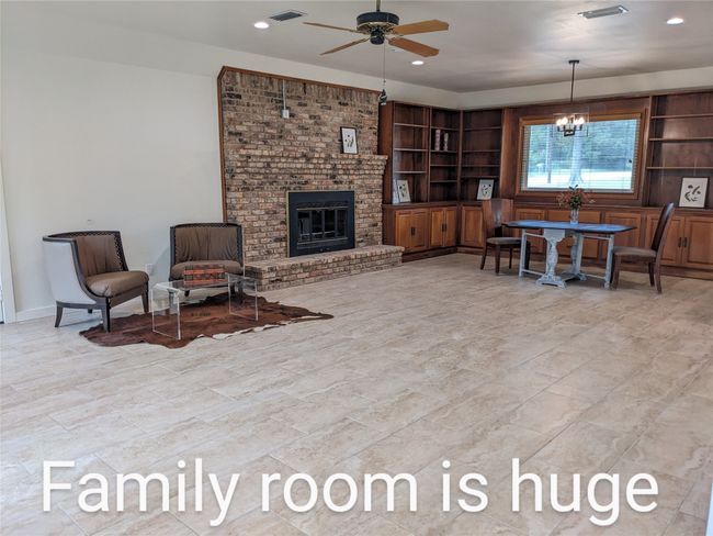 Living room featuring a ceiling fan, a chandelier, a fireplace, and recessed lighting | Image 13