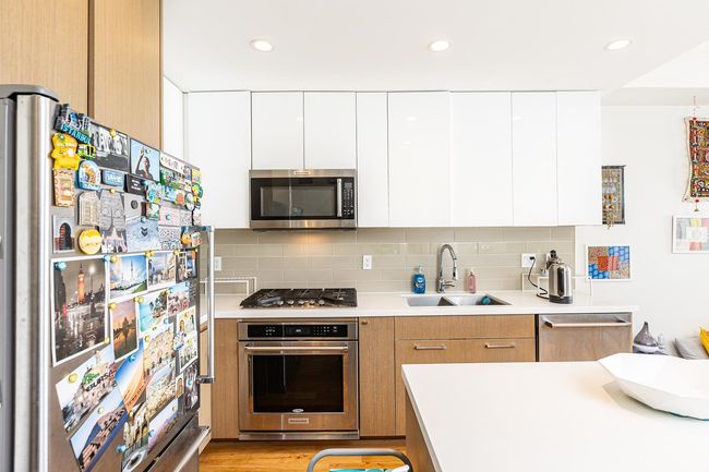 Kitchen featuring stainless steel appliances, a sink, modern cabinets, light countertops, and recessed lighting | Image 5
