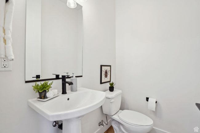 Half bathroom featuring baseboards, a sink, and toilet | Image 12