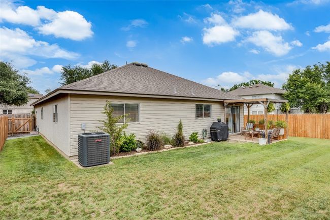 Back of property with central air condition unit, a patio, a shingled roof, and a gazebo | Image 27