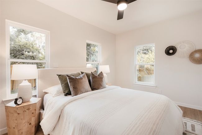 Bedroom featuring wood finished floors, multiple windows, and ceiling fan | Image 19