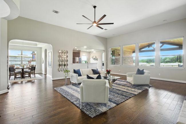 Living area with arched walkways, dark wood-style floors, healthy amount of natural light, and ceiling fan | Image 8