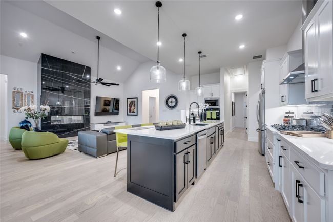 Cook's kitchen with gas cooktop, light countertops, stainless steel appliances, and white cabinets | Image 6