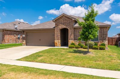 View of front facade with a garage, a front yard, and central AC unit | Image 2