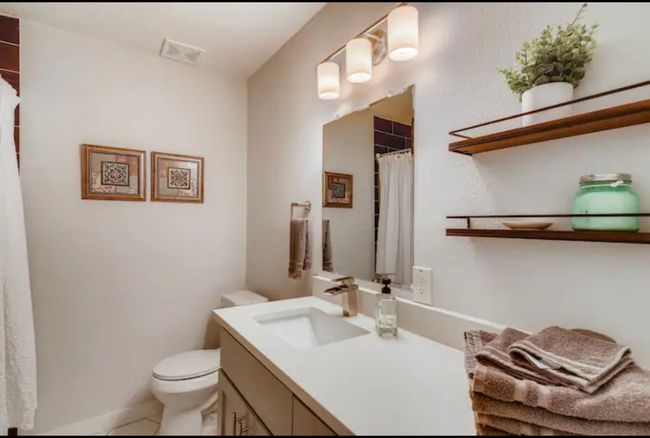 Full bathroom featuring vanity, toilet, a shower with shower curtain, and tile patterned floors | Image 16