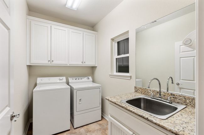 Laundry room featuring a sink, washing machine and clothes dryer, cabinet space, and baseboards | Image 18