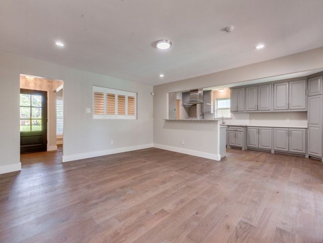 Unfurnished living room with light wood finished floors, baseboards, a sink, and recessed lighting | Image 6