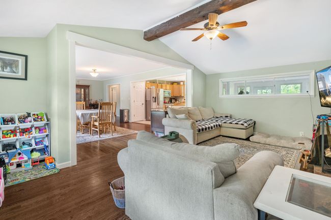 Living room featuring dark wood-style floors, ceiling fan, and baseboards | Image 15