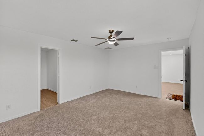 Carpeted spare room featuring a ceiling fan and baseboards | Image 17