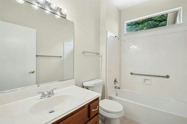 Bathroom featuring toilet, vanity, and washtub / shower combination | Image 15