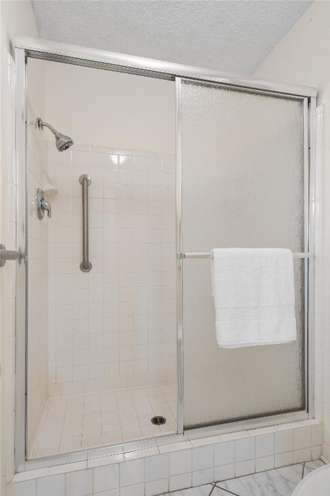 Bathroom featuring a stall shower and a textured ceiling | Image 22