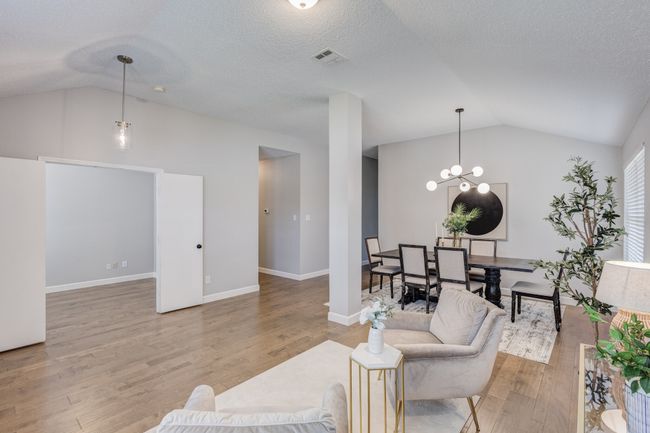 Living room featuring light wood-style floors, high vaulted ceiling, a chandelier, and baseboards | Image 5