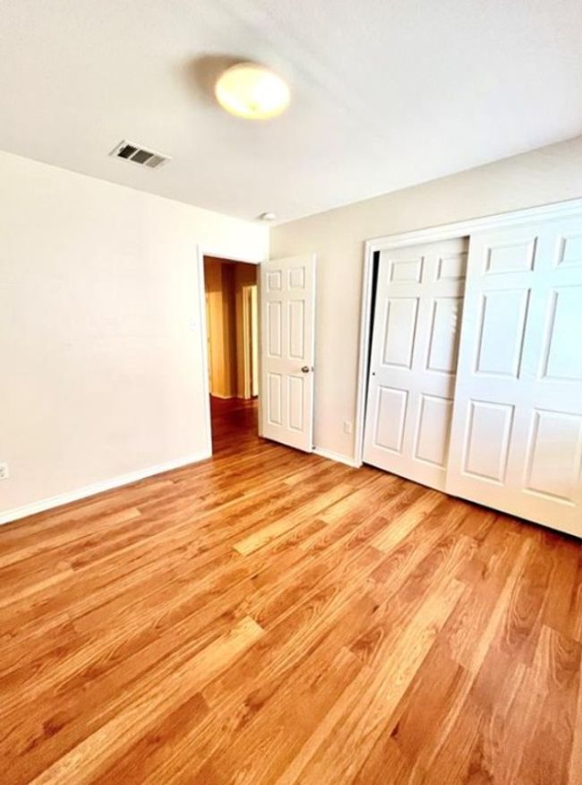 Unfurnished bedroom with light wood finished floors, a closet, and baseboards | Image 12