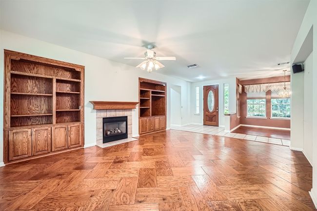 Unfurnished living room with baseboards, ceiling fan, and a tiled fireplace | Image 8