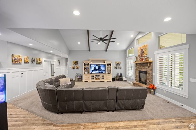 Living room with ceiling fan, a stone fireplace, wood finished floors, recessed lighting, and baseboards | Image 6