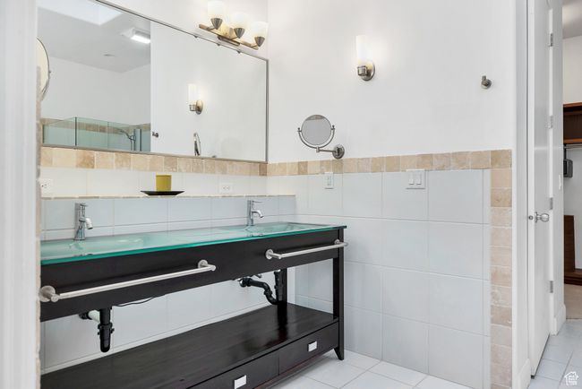 Full bathroom with tile walls, a sink, and tile patterned flooring | Image 21