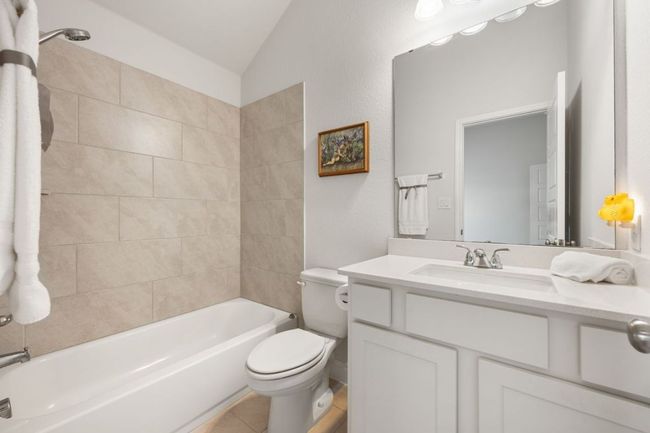 Full bath with tile patterned floors, toilet, shower combination, vanity, and vaulted ceiling | Image 23
