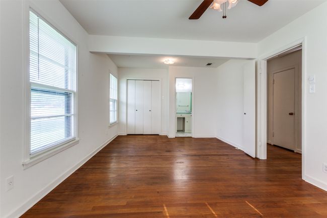 bedroom with wood finished floors, a ceiling fan and ensuite bath. | Image 11