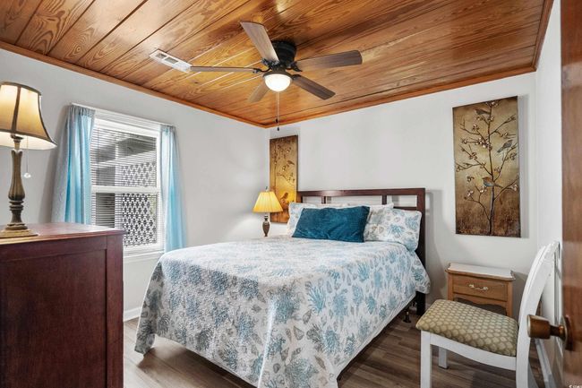 Bedroom featuring wooden ceiling, wood finished floors, crown molding, and a ceiling fan | Image 34
