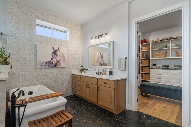 Full bathroom featuring marble style finish floor, a freestanding bath, and vanity | Image 31