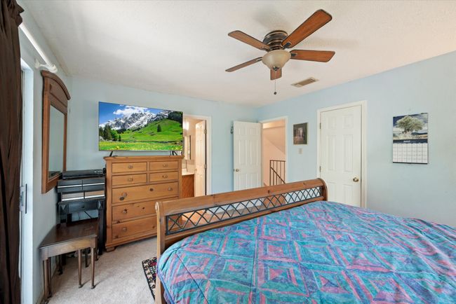 Carpeted bedroom featuring ensuite bath and ceiling fan | Image 23