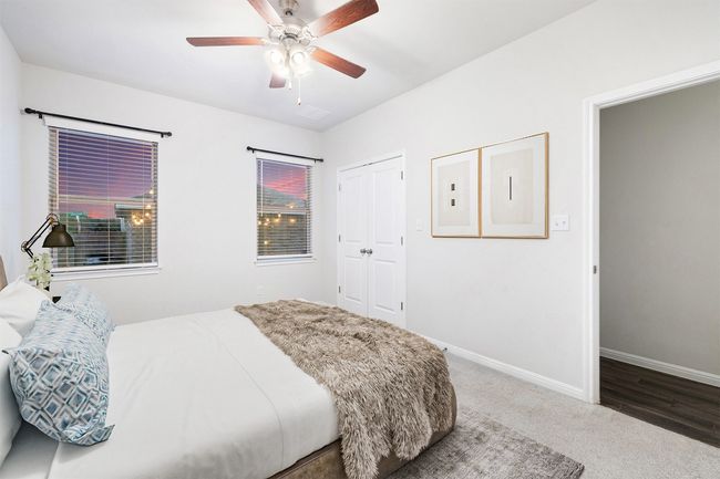 Bedroom with a ceiling fan, baseboards, electric panel, a closet, and carpet flooring | Image 12
