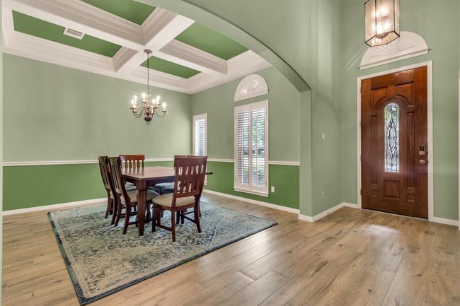 Dining area featuring hardwood / wood-style floors, arched walkways, baseboards, coffered ceiling, and beam ceiling | Image 12