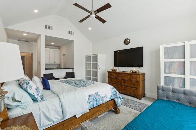 Bedroom with light colored carpet, high vaulted ceiling, ceiling fan, recessed lighting, and baseboards | Image 23