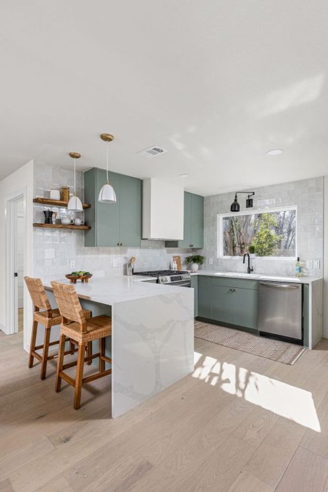Kitchen with stainless steel appliances, green cabinetry, light wood-style floors, a peninsula, and tasteful backsplash | Image 14